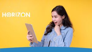 10 Razones por las que España es el Destino Favorito para los Nómadas Digitales - Mujer sorprendida mirando una tablet, con el logo de Horizon sobre un fondo amarillo brillante.